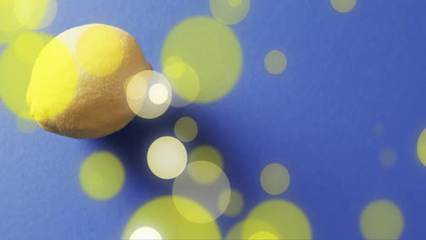 composition of lemon and spots of light over blue background