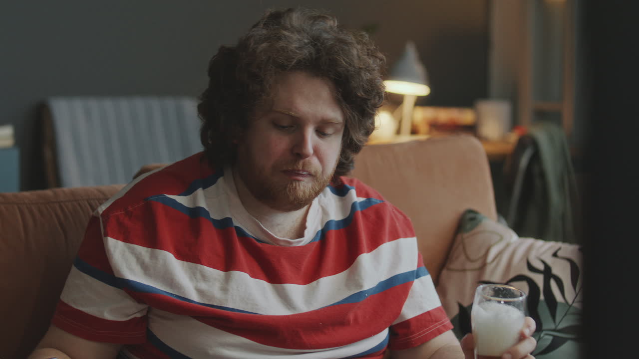 Man watching something while drinking