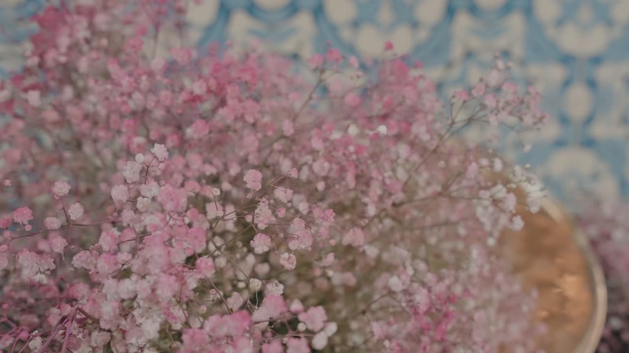Primo piano sognante di fiori di gypsophila rosa e bianchi a fuoco morbido su piastrelle decorate