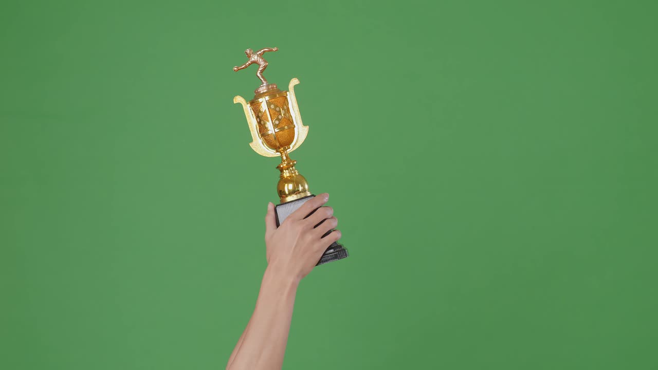 mano sosteniendo un trofeo dorado contra un fondo verde