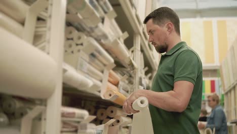 man shopping for wallpaper in a home improvement store