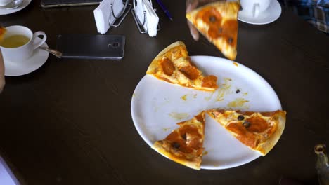 amigos compartiendo una pizza en un restaurante - manos tomando una pizca margarita rebanada - conceptos sobre comida, nutrición, fiesta y amistad.