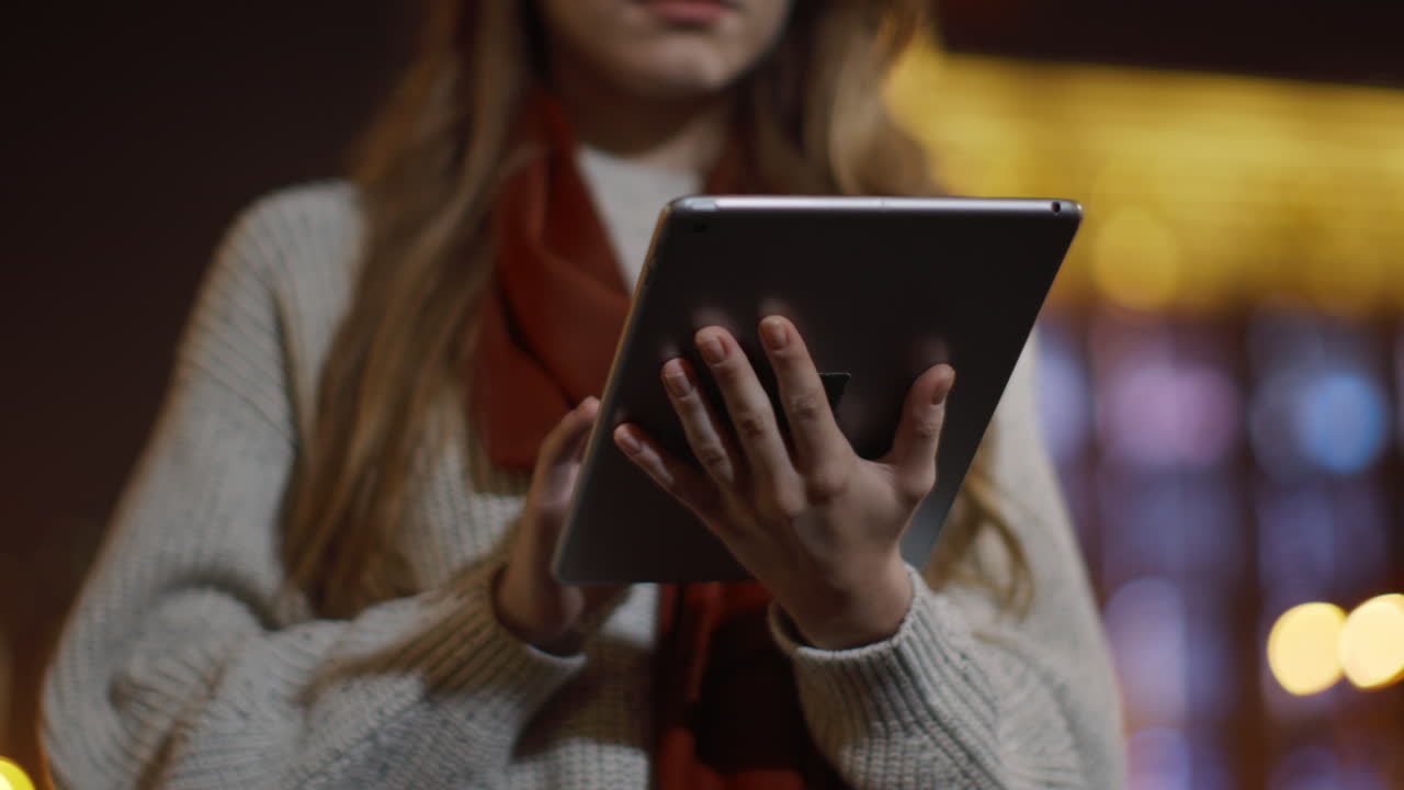 las manos de la mujer enviando mensajes de texto en la tableta al aire libre. niña desconocida tocando la pantalla de la tableta.