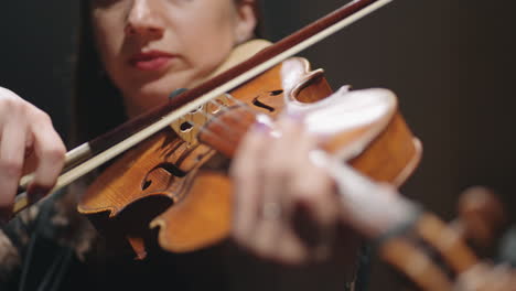 adult woman is playing viola in opera house or philharmonic hall female fiddler is playing violin in music hall