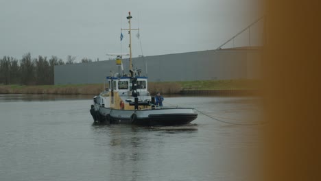 hombre en un bote pequeño está tirando de una cuerda cerca del puerto