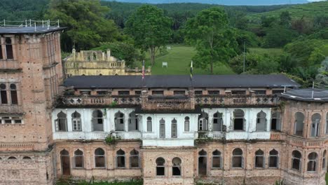 grand reverse aerial shot of historic kellie's castle, capturing the details facade of moorish revival architecture and beautiful rooftop balcony at batu gajah, kinta district, perak, malaysia