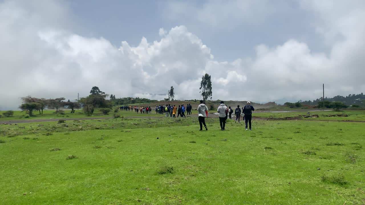 Group hikers is going to waterfall area in Debre Libanos, Debre Birhan, on very green field and close to the clouds.