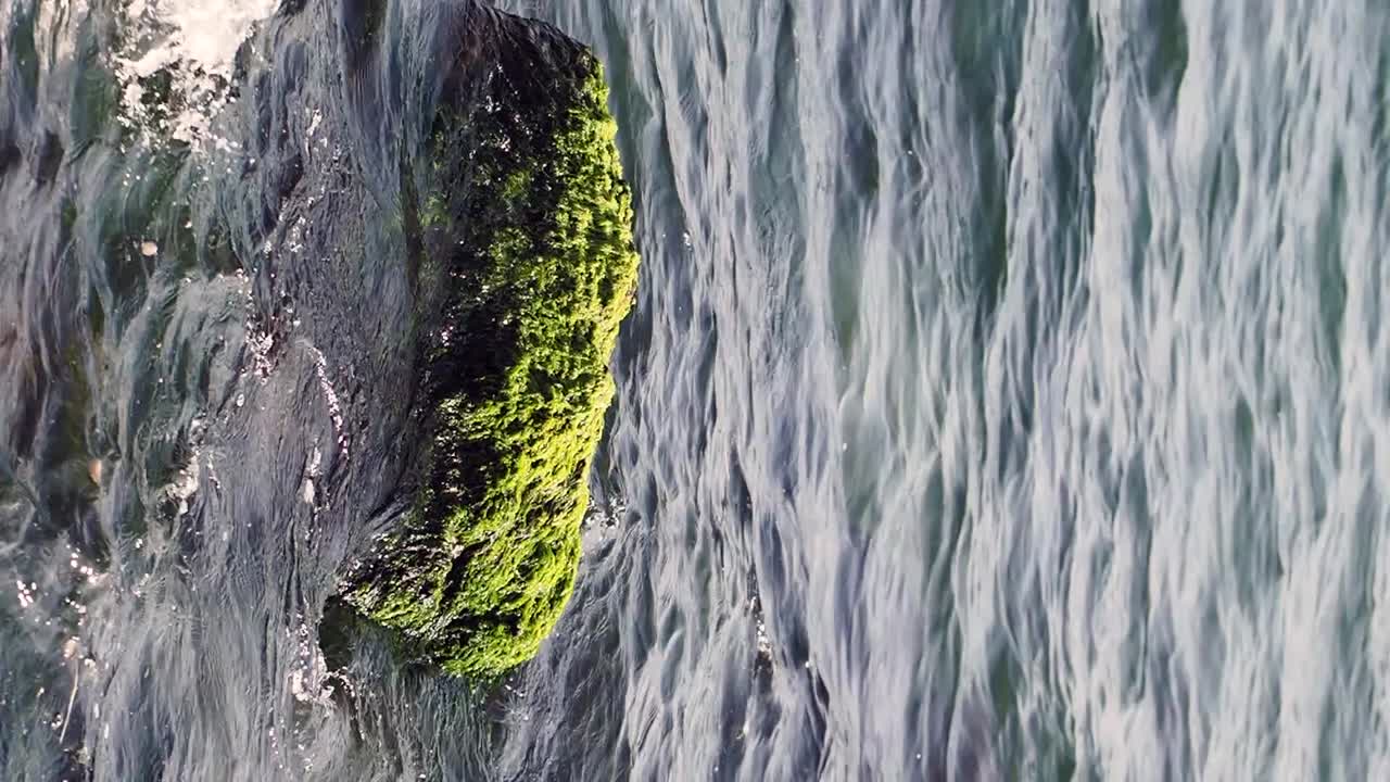 Rock with moss in flowing water