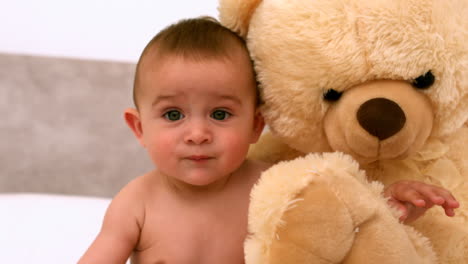 cute baby on a bed with teddy bear