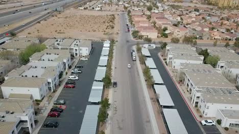 aerial flyover, low altitude apartment complex with car diving into residential neighboorhood