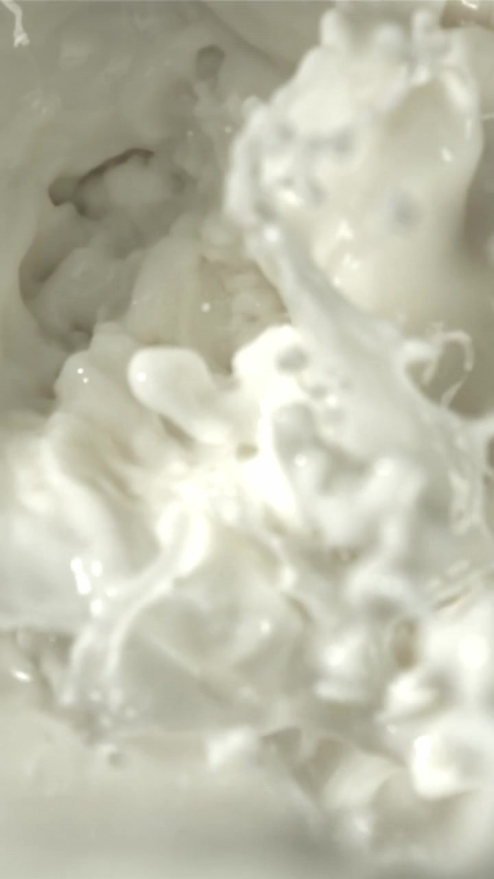 Macro di latte bianco che schizza e forma vortici