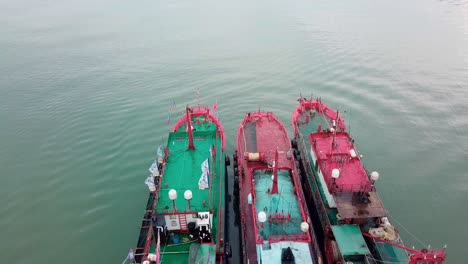 three ships anchored in a bay in asia