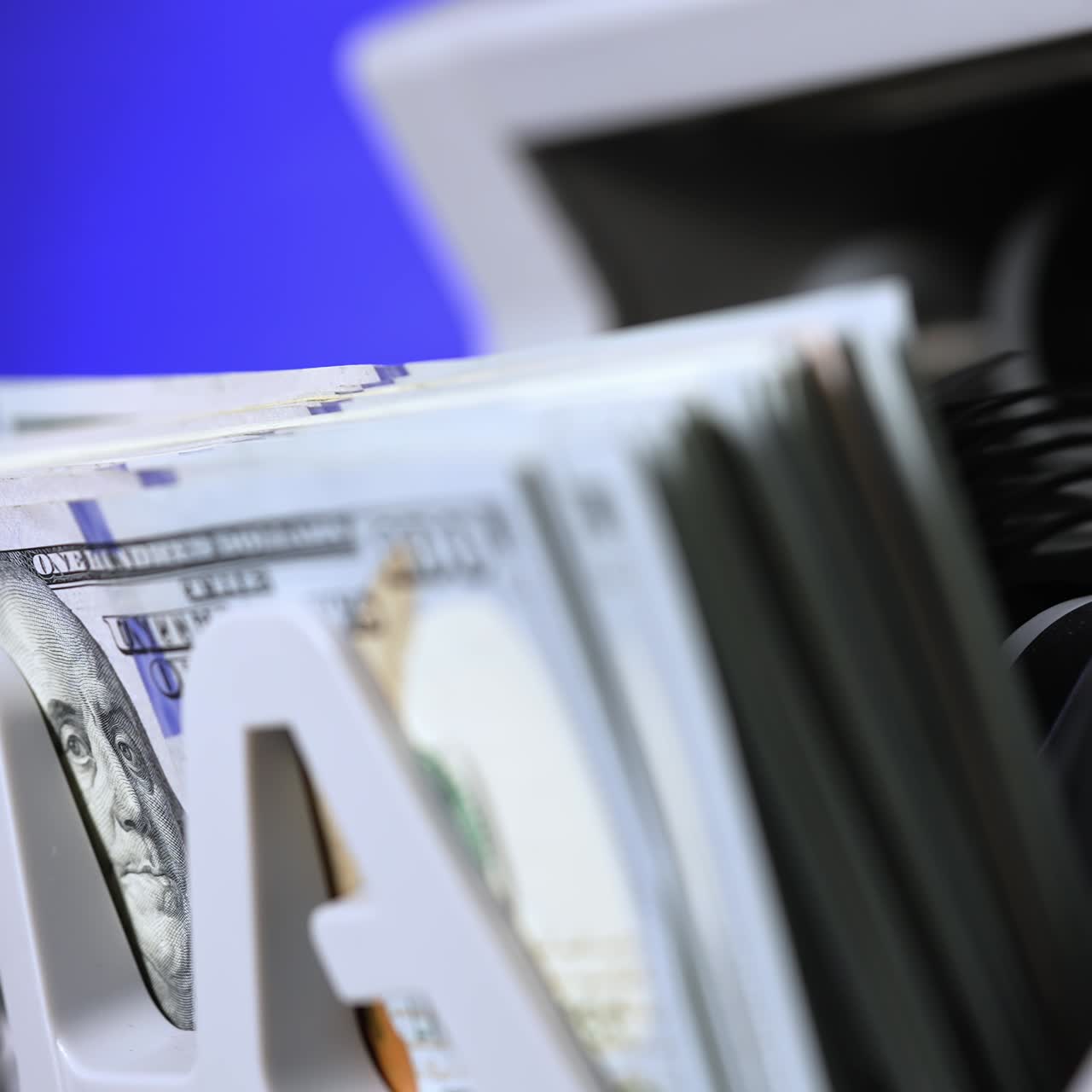 Cash money counting machine. Banknote counter are counting hundred dollar bills. Close-up