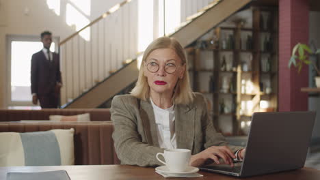 Senior-Businesswoman-Using-Laptop-in-Restaurant