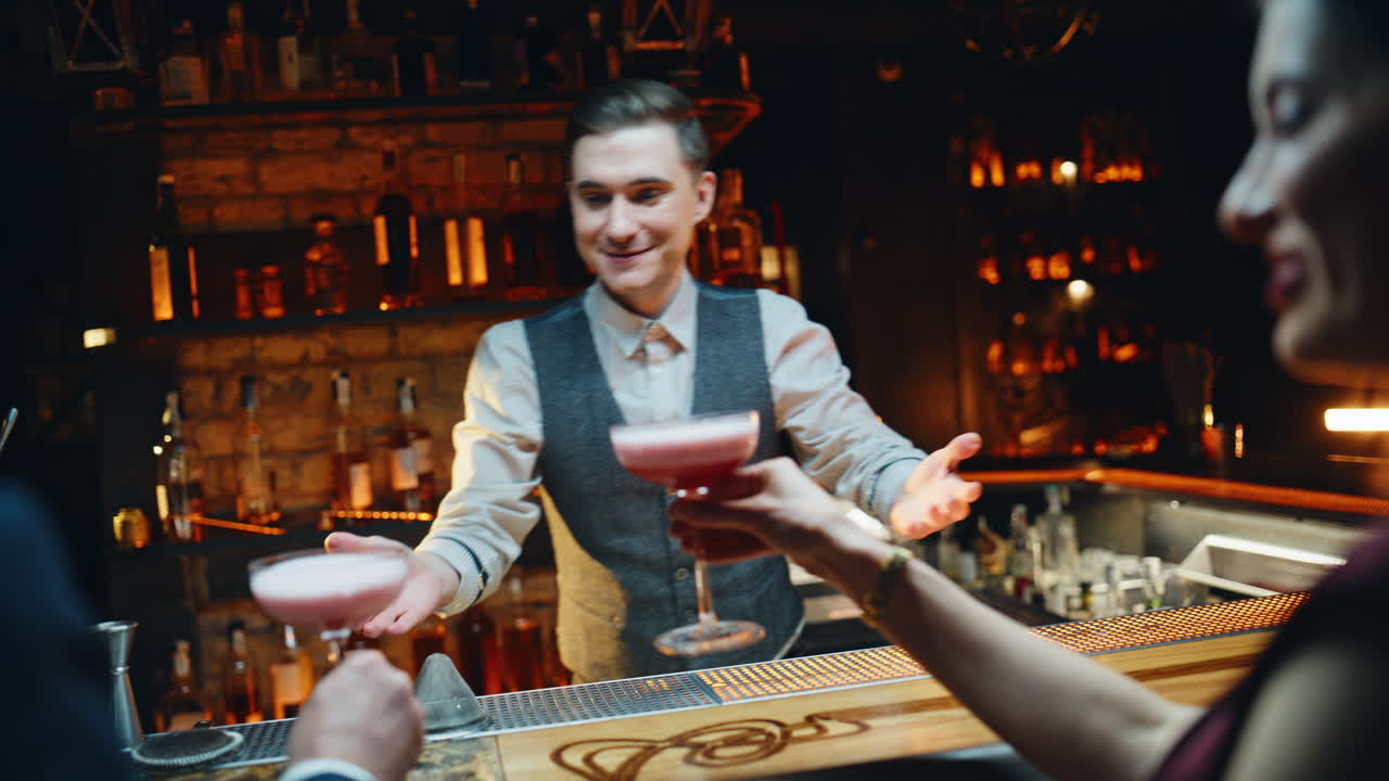 Energiereiche/r KellnerIn serviert Getränke an der Bar für Gäste aus der Nähe. Souveräne/r BarkeeperIn