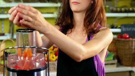 female staff preparing fresh juice in juicer