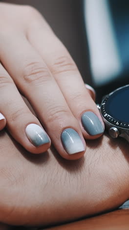 elegant woman with stylish manicure strokes hand of beloved man with wristwatch spending time together closeup. affection and romantic relationship