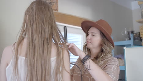 woman getting her hair styled in a kitchen