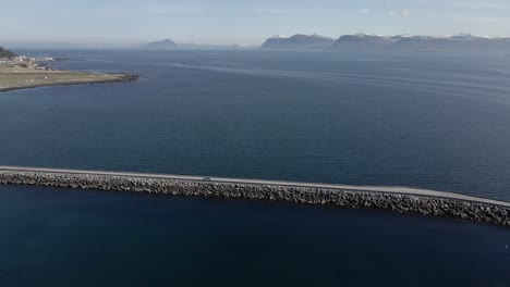 Toma-Aérea-De-Seguimiento-De-Un-Vehículo-Circulando-Por-El-Puente-Runde-Durante-Un-Día-Soleado-En-Noruega,-Europa.