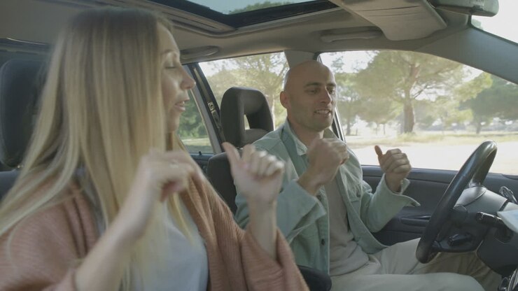 Coppia felice che balla in auto.