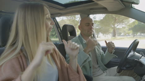 happy couple dancing in car