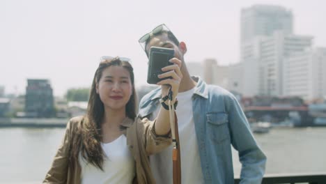 young asian couple tourist using polaroid camera take photo.