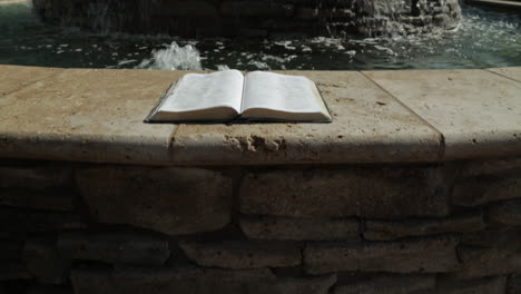 approaching a holy book by a peaceful water fountain