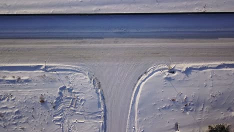 t-shaped crossroad on a winter sunny day. action. aerial top view of a countryside road segment covered by snow