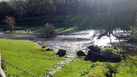 slow motion saturated flooded countryside stream burst its banks with submerged trees after storm weather