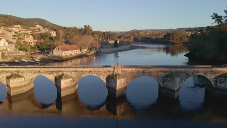 Eine-Totale-Wurde-Von-Einem-Fluss-Aufgenommen,-Wo-Ein-Auto-über-Eine-Brücke-Fuhr