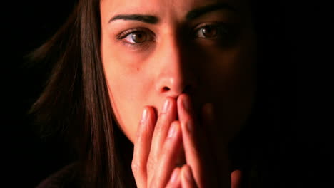 upset brunette looking to camera on black background