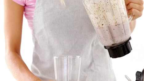 Beautiful-woman-pouring-smoothie-in-glass