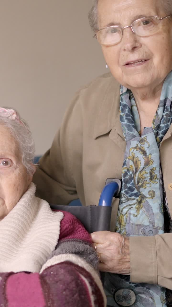 Senior women looking at camera together in a nursing home