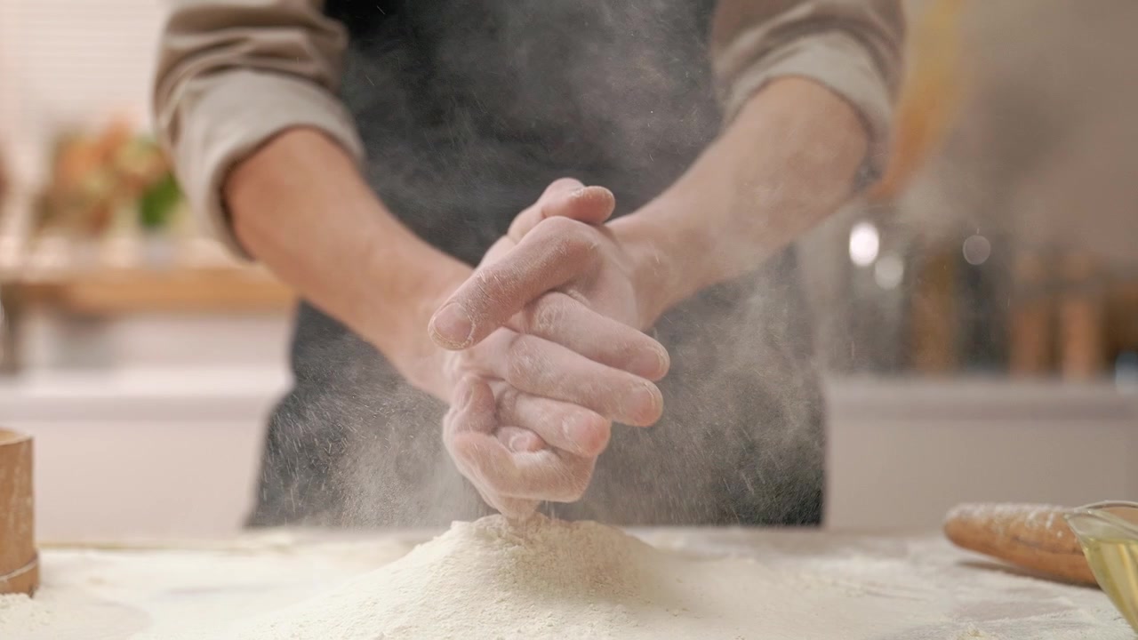 Chef che batte le mani coperte di farina al rallentatore