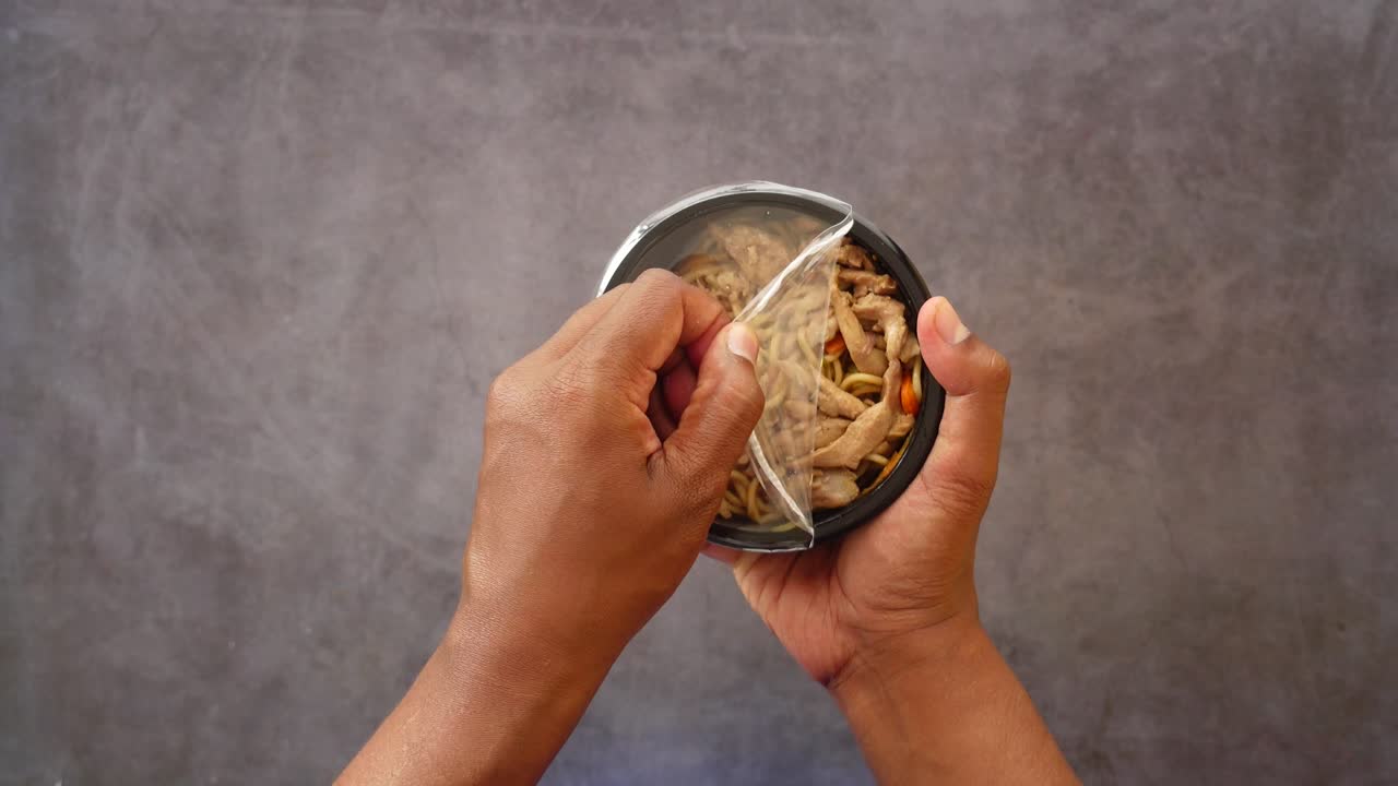 Opening a Container of Chicken Noodle Stir-Fry