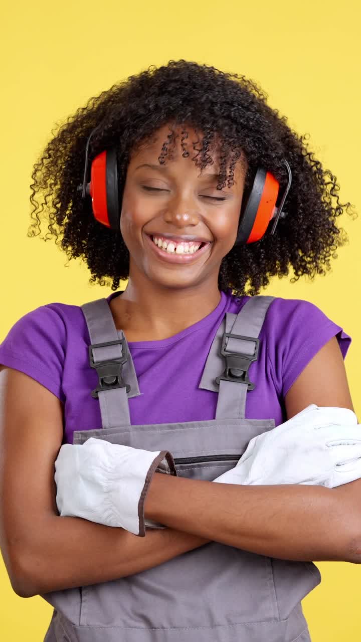 Lavoratrice sorridente in tuta da lavoro e cuffie antirumore.