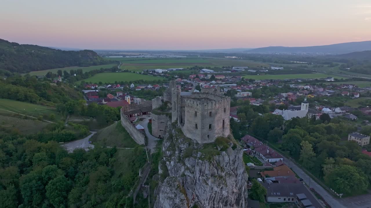 Vue de drone du château de Beckov, alors que les couleurs du coucher de soleil embrasent le ciel