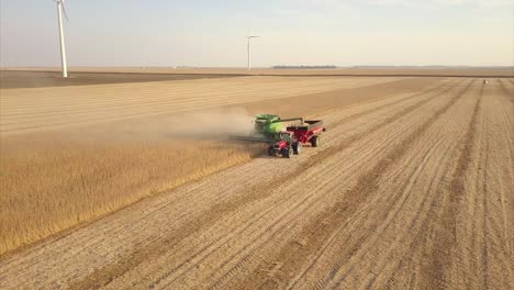 Un-Agricultor-Del-Medio-Oeste-Cosechando-Un-Campo-De-Soja-Con-Una-Cosechadora,-Un-Tractor-Y-Un-Vagón-De-Barrena