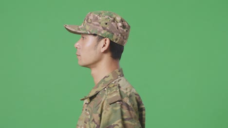 cerca de vista lateral hombre asiático soldado caminando en la pantalla verde estudio de fondo