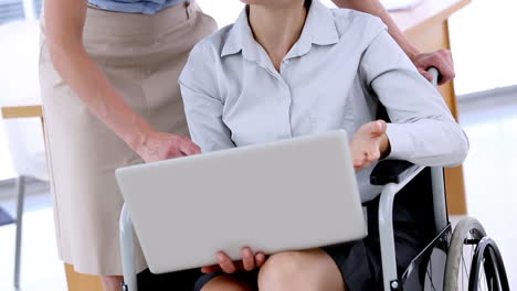 mujer de negocios en silla de ruedas trabajando con una computadora portátil
