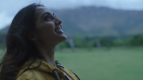 independent-young-indian-woman-looking-up-smiling-happy-wind-blowing-hair-enjoying-gentle-breeze-on-travel-adventure-alone-in-peaceful-countryside