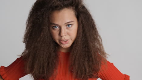 angry caucasian curly haired woman looking to the camera.