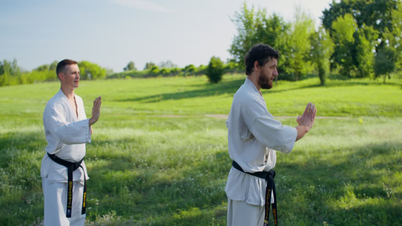 Due uomini che praticano karate all'aperto