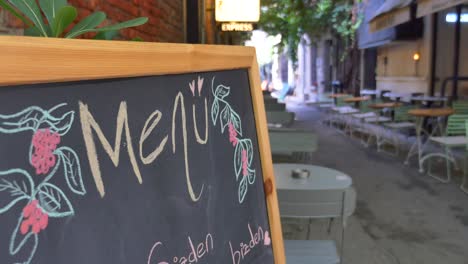 outdoor cafe menu board in a city alley