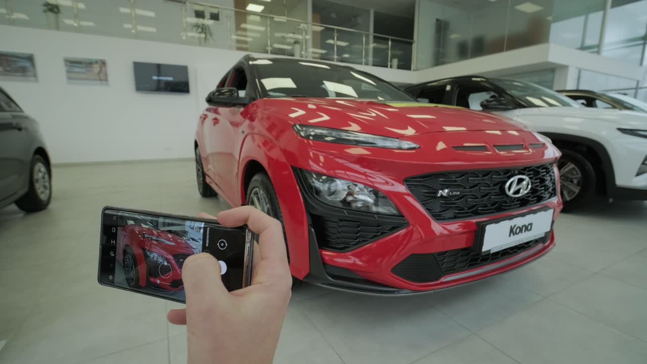 concesionario de automóviles hyundai. el gerente de concesionarios toma fotos de un automóvil nuevo para la venta. una visión general de los nuevos automóviles de prestigio en la sala de exhibición. sars para la venta en concesionista oficial de hyundai
