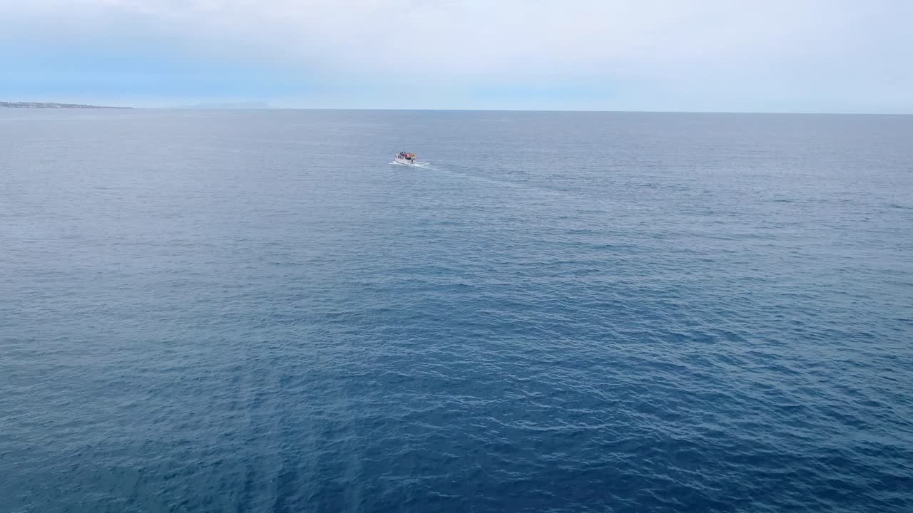 Aerial of a boat sailing and people doing jet ski in the Aegean Sea near Crete, Greece