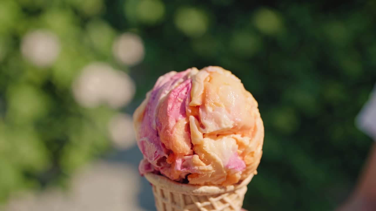 Melting multicolored ice cream drips from a crispy waffle cone, creating a refreshing and delightful treat on a bright summer day, perfect for enjoying outdoors
