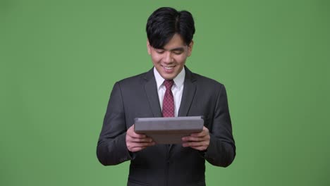 young handsome asian businessman using digital tablet