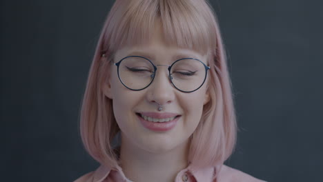 portrait of a young woman with pink hair and glasses