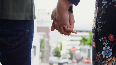 pareja de manos mientras caminan por la calle 4k